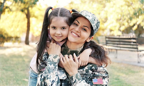 A female military veteran in uniform with her young daughter